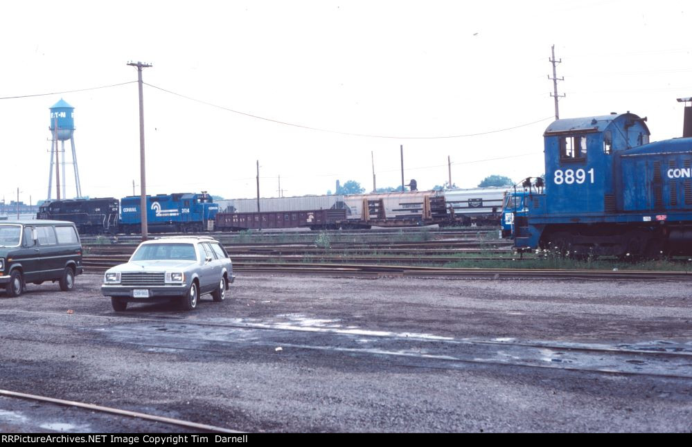 CR 8891 sits as 3114, 3083 work on a freight.